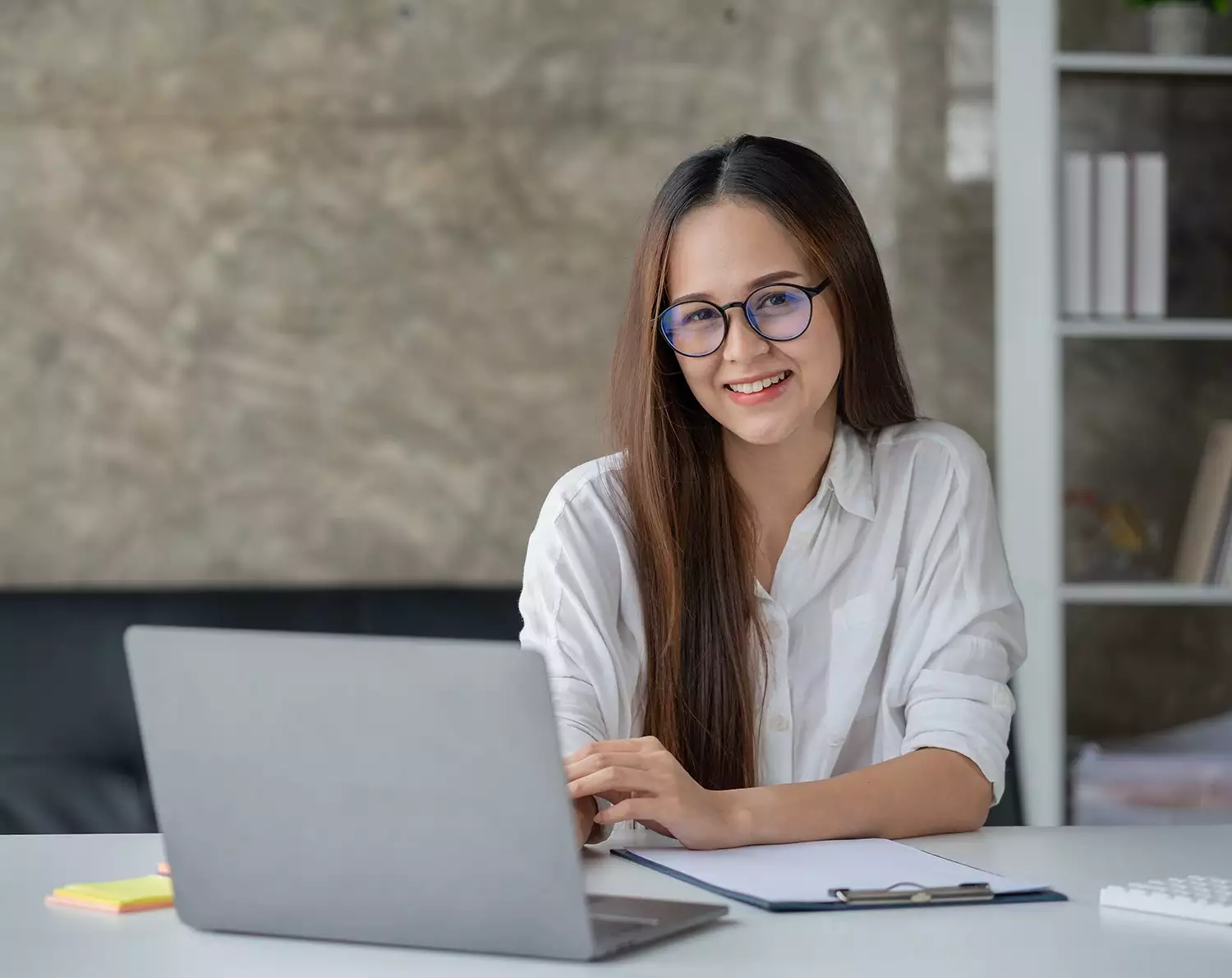 Smiling Young Woman Working on a Laptop